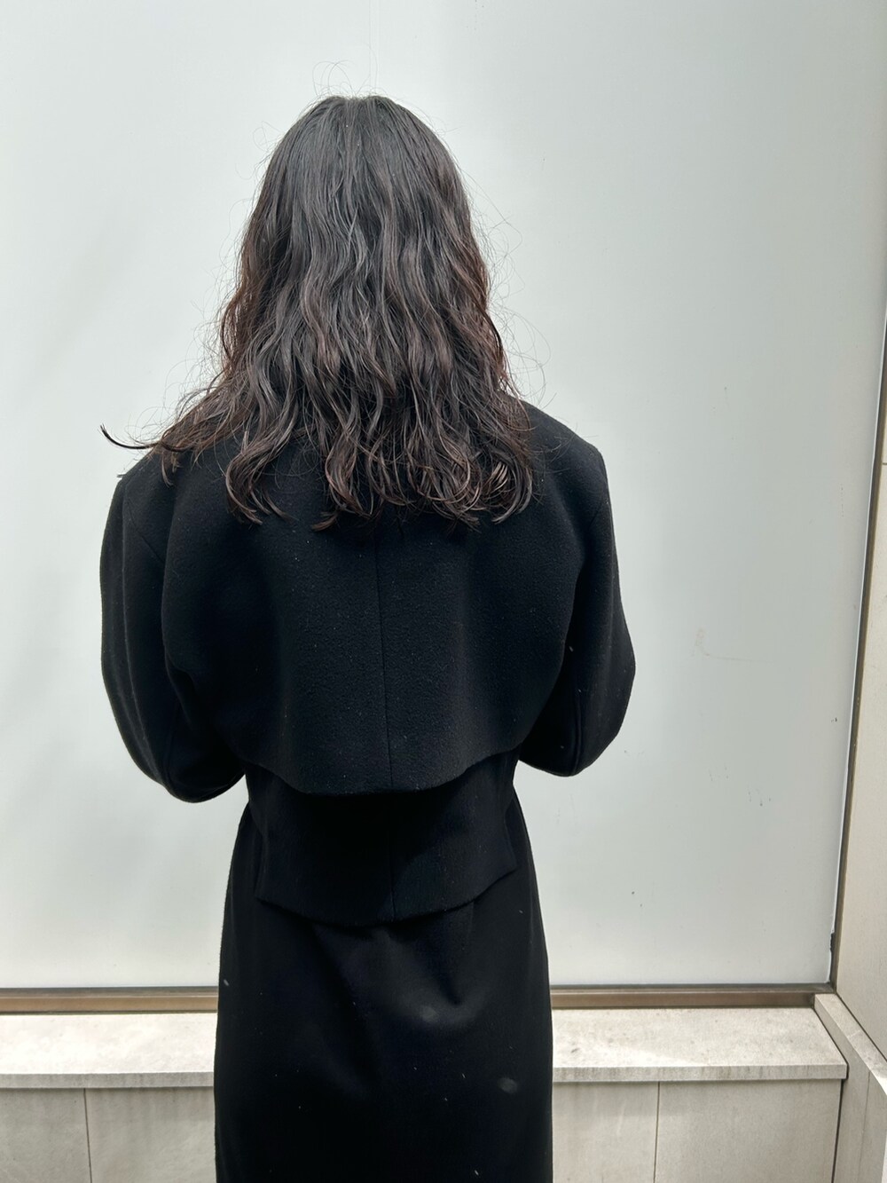 グレー系のテーラードジャケット、ホワイト系のワンピース、ブラック系のパンプスを着用したレディースの夏コーディネートの4枚目の写真