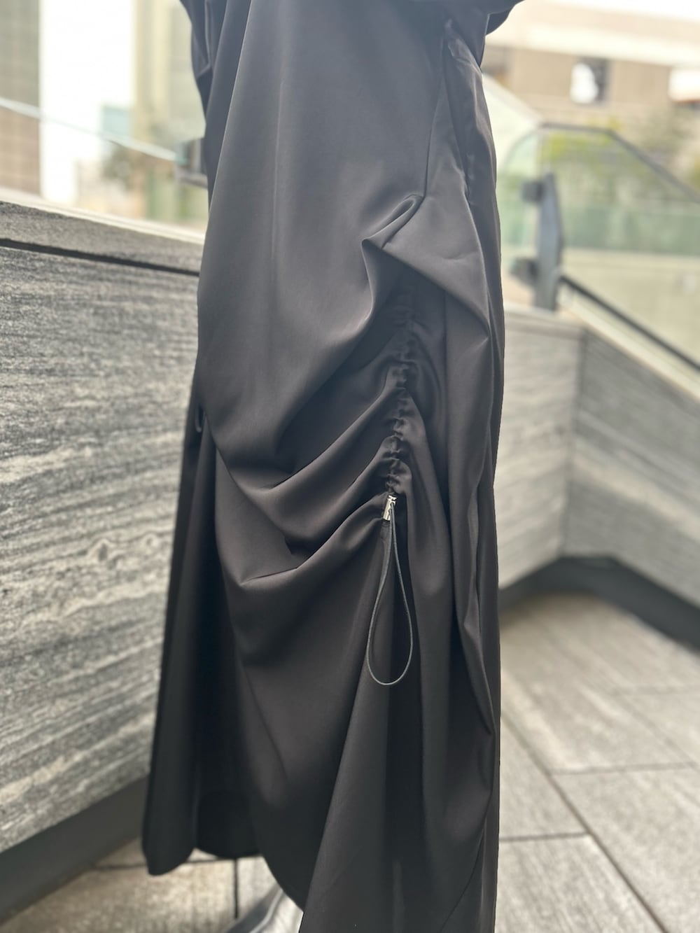 ブラック系のワンピース、ブラック系のテーラードジャケット、シルバー系のブーツを着用したレディースの春コーディネートの9枚目の写真