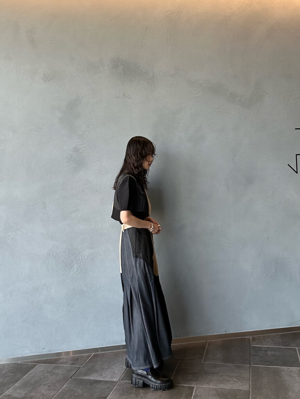 ベージュ系のスカート、ベージュ系のベスト、ブラック系のニット/セーターを着用したレディースの夏コーディネートの3枚目の写真