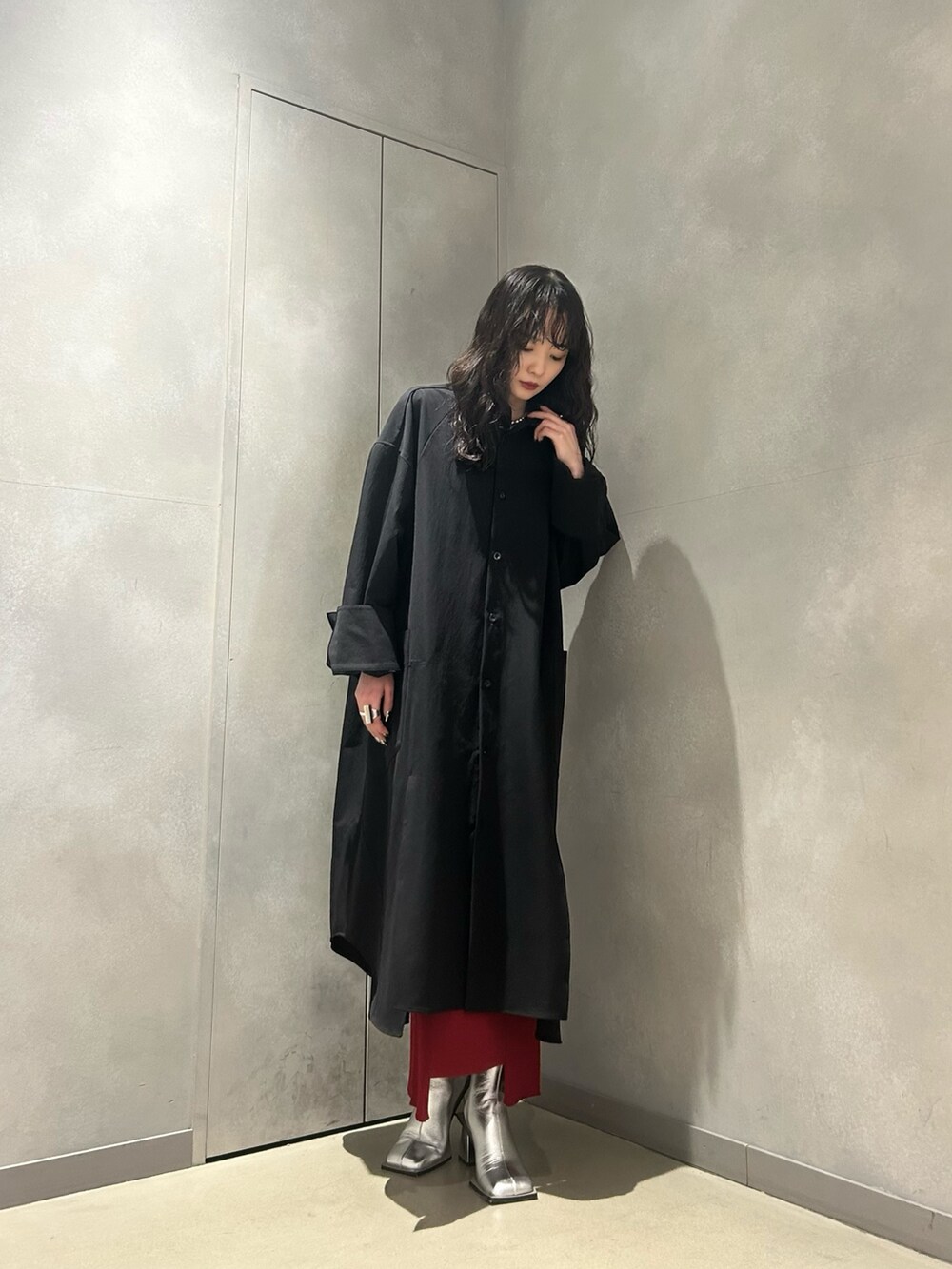 ブラック系のワンピース、レッド系のスカート、シルバー系のブーツを着用したレディースの冬コーディネートの3枚目の写真