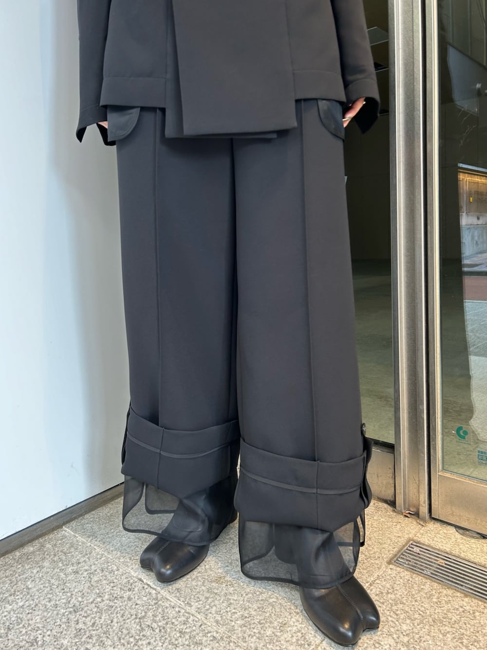 ブラック系のテーラードジャケット、ブラック系のその他アウター、ブラック系のブーツを着用したレディースの冬コーディネートの6枚目の写真