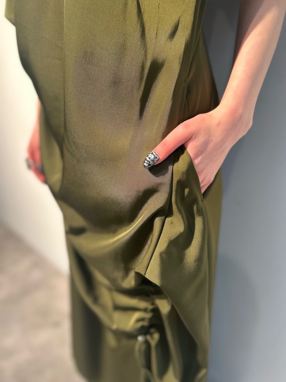 グリーン系のワンピース、ホワイト系のタンクトップ、シルバー系のパンプスを着用したレディースの春コーディネートの7枚目の写真