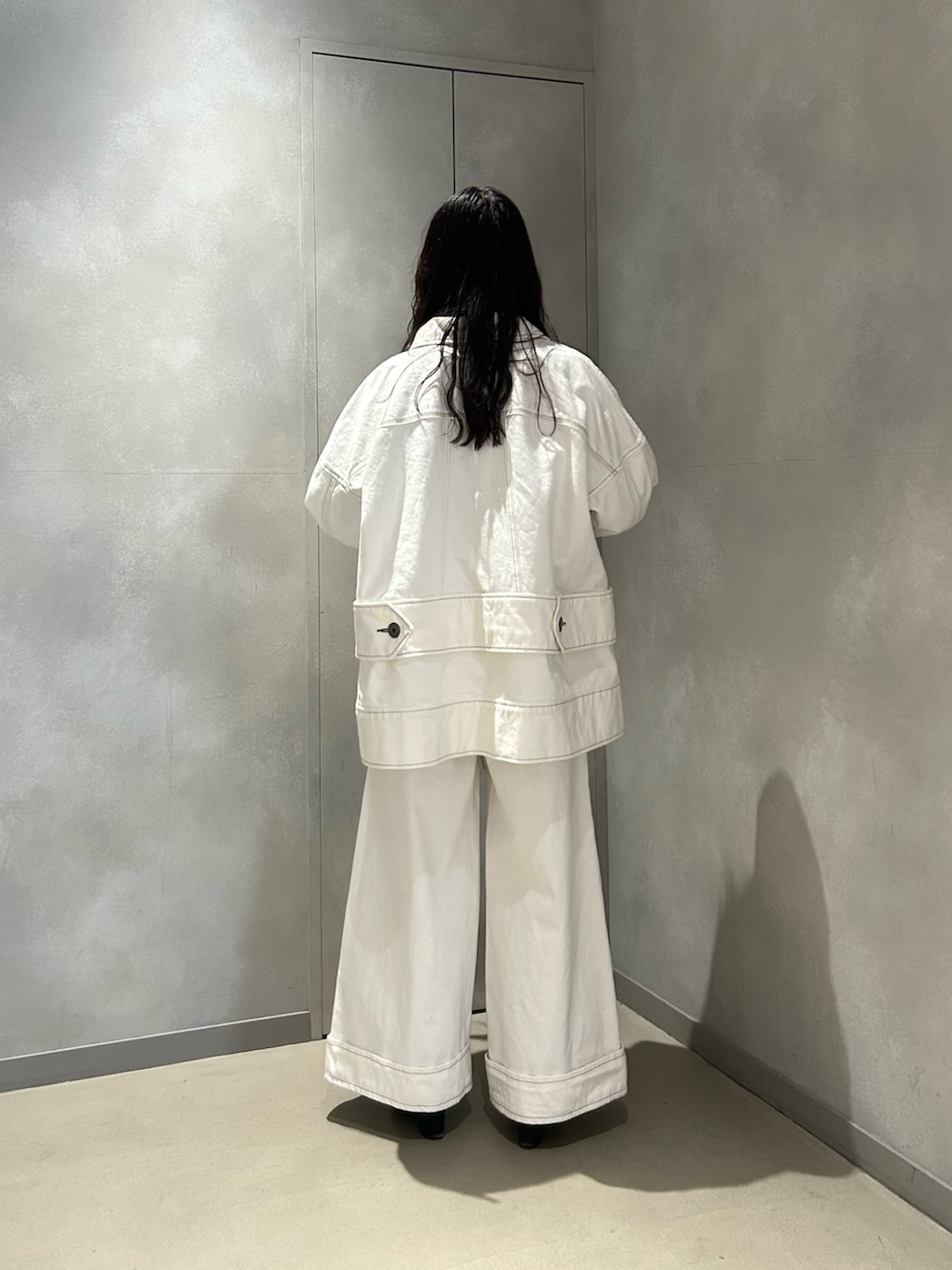 ホワイト系のデニムパンツ、ホワイト系のデニムジャケット、ブラック系のニット/セーターを着用したレディースの春コーディネートの5枚目の写真