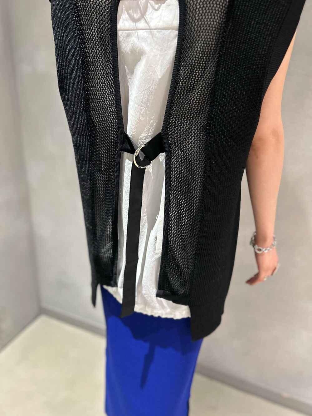 ブラック系のベスト、ホワイト系のシャツ/ブラウス、ブルー系のスカートを着用したレディースの夏コーディネートの5枚目の写真