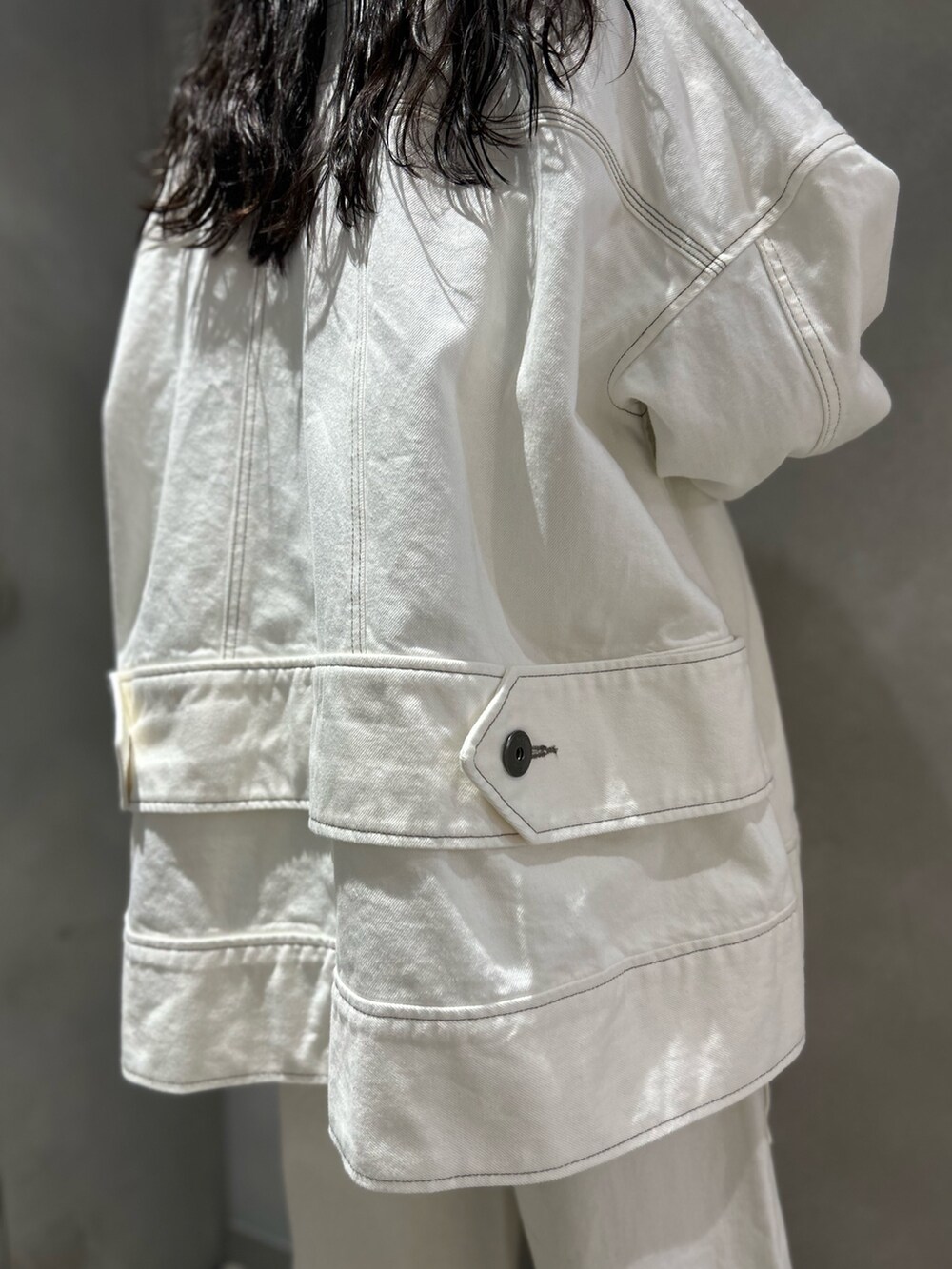 ホワイト系のデニムパンツ、ホワイト系のデニムジャケット、ブラック系のニット/セーターを着用したレディースの春コーディネートの9枚目の写真