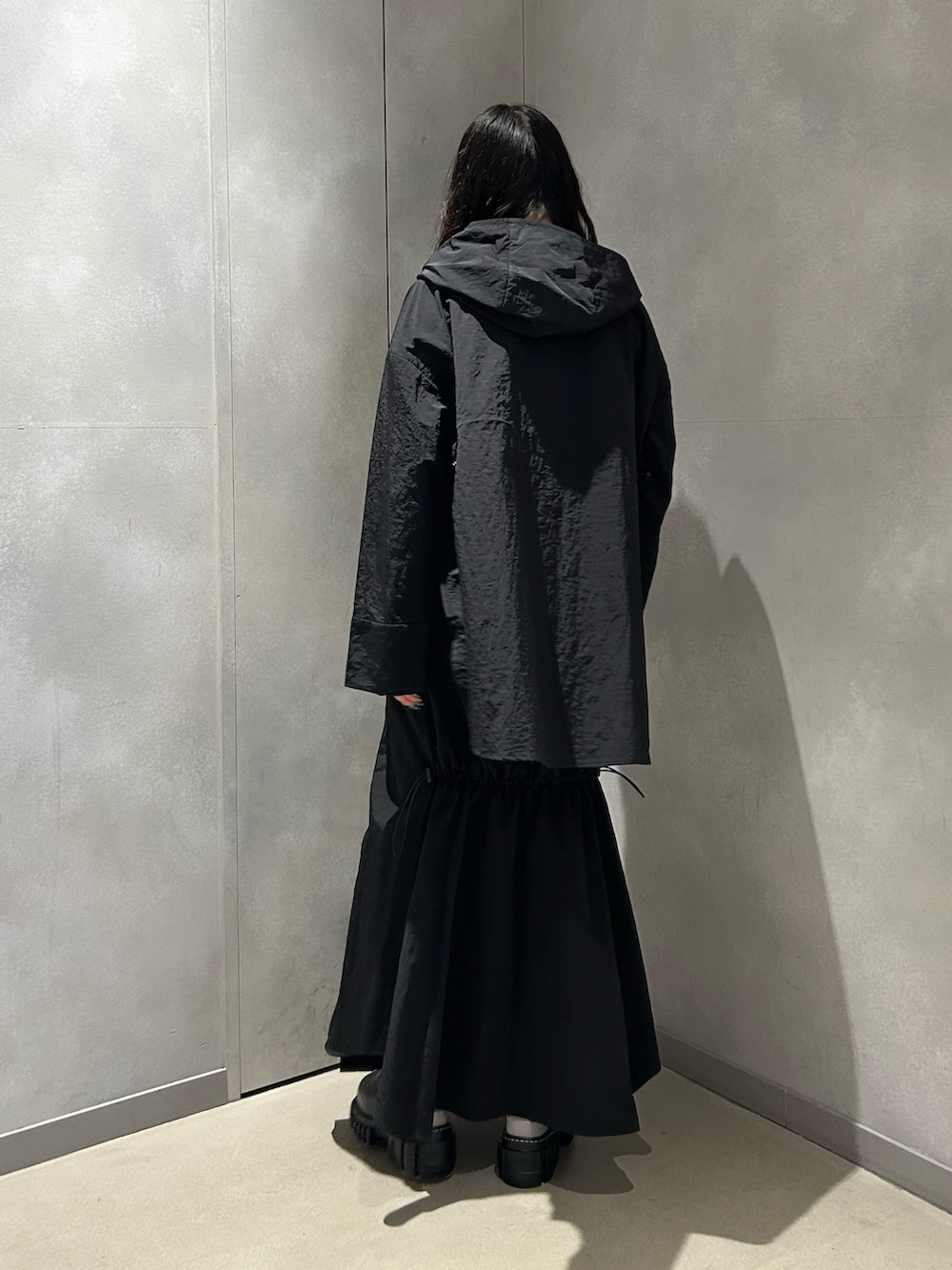 ブラック系のマウンテンパーカー、ブラック系のスカート、その他のサンダルを着用したレディースの春コーディネートの4枚目の写真