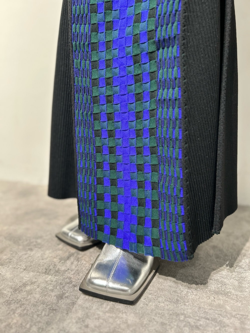 シルバー系のブーツ、ブラック系のスカート、ホワイト系のタンクトップを着用したレディースの冬コーディネートの10枚目の写真