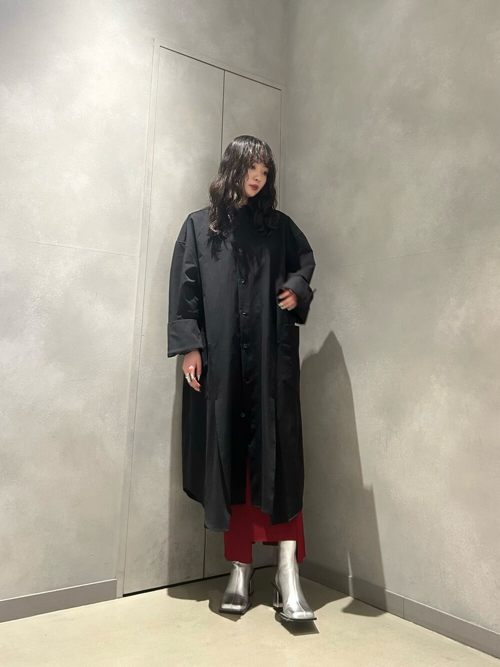 ブラック系のワンピース、レッド系のスカート、シルバー系のブーツを着用したレディースの冬コーディネートの2枚目の写真