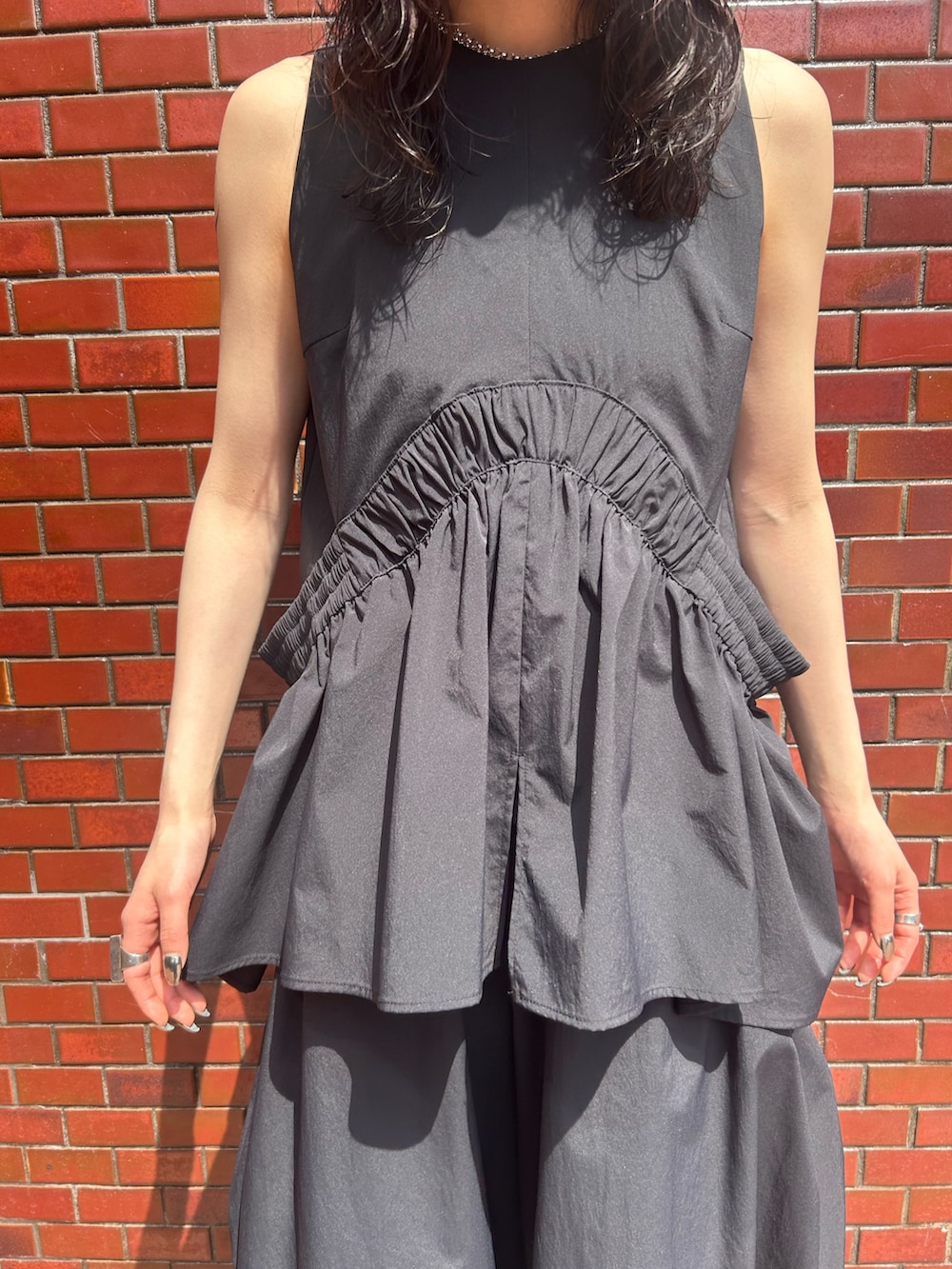 ブラック系のその他パンツ、ブラック系のタンクトップ、シルバー系のネックレスを着用したレディースの春コーディネートの4枚目の写真