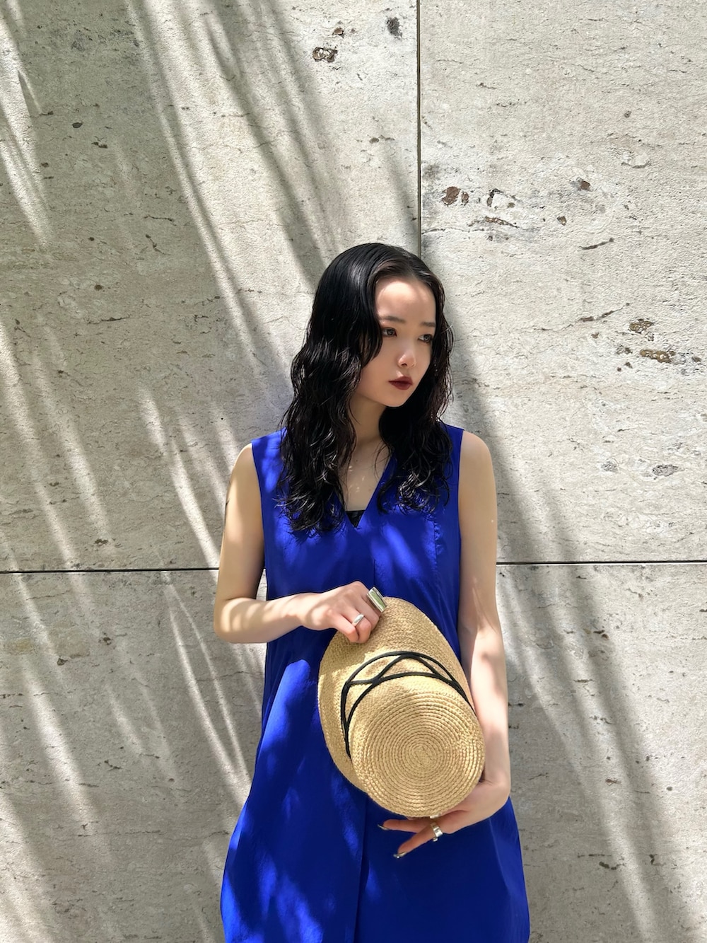 ブルー系のワンピース、シルバー系のサンダル、ベージュ系のハットを着用したレディースの春コーディネートの2枚目の写真