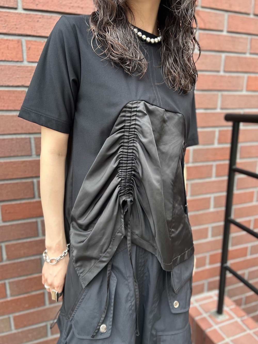 ブラック系のTシャツ/カットソー、ブラック系のスカート、ブラック系のローファーを着用したレディースの秋コーディネートの7枚目の写真
