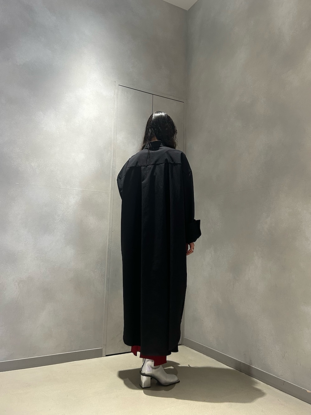 ブラック系のワンピース、レッド系のスカート、シルバー系のブーツを着用したレディースの冬コーディネートの4枚目の写真