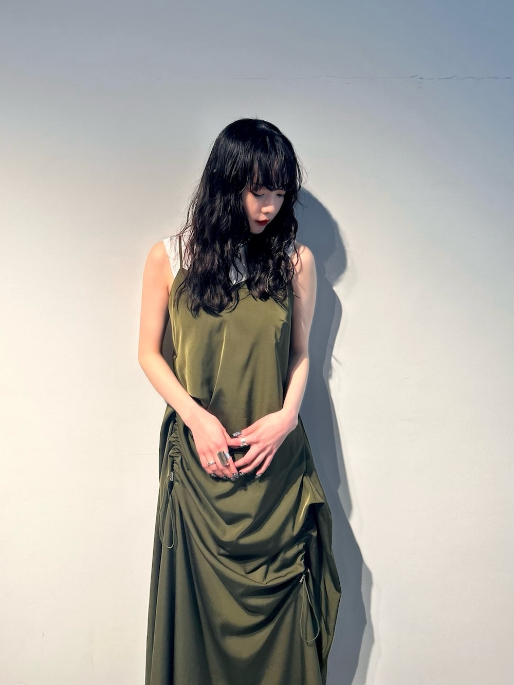 グリーン系のワンピース、ホワイト系のタンクトップ、シルバー系のパンプスを着用したレディースの春コーディネートの2枚目の写真