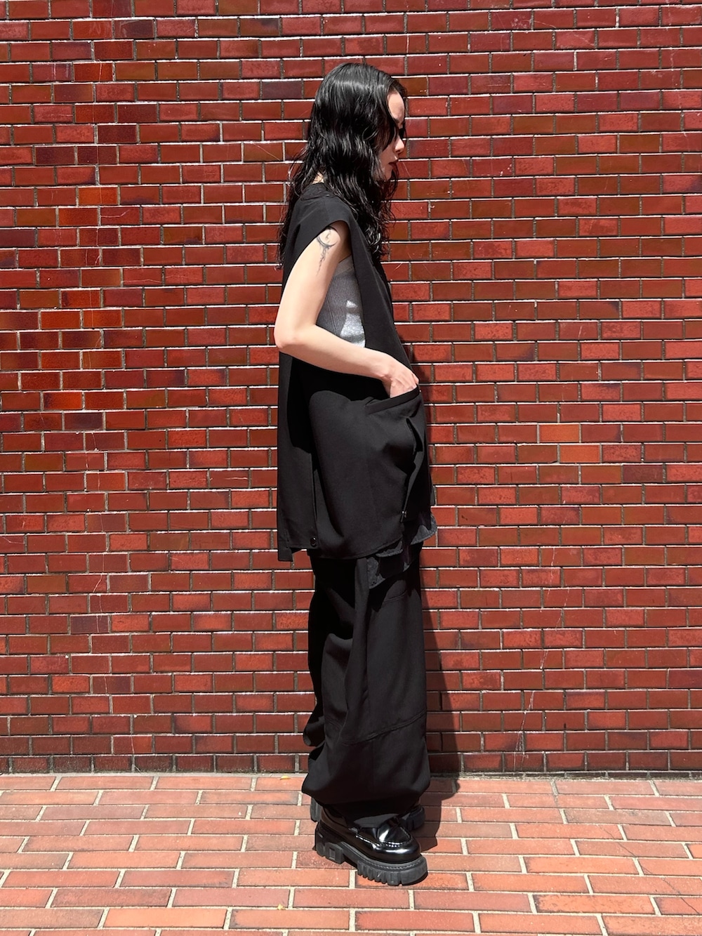 ブラック系のその他パンツ、シルバー系のタンクトップ、ブラック系のベストを着用したレディースの春コーディネートの4枚目の写真