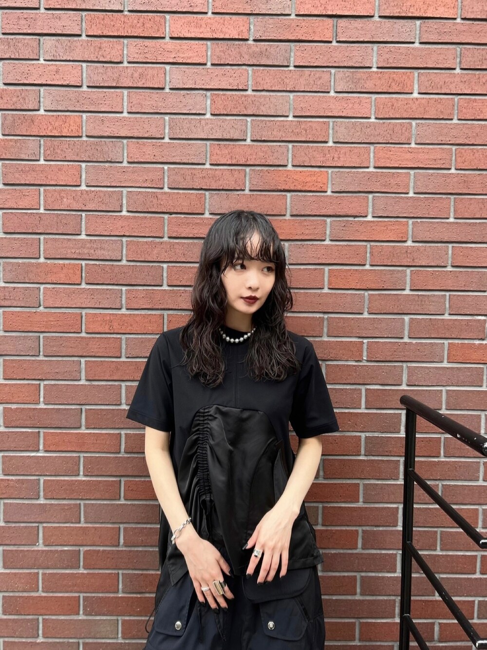 ブラック系のTシャツ/カットソー、ブラック系のスカート、ブラック系のローファーを着用したレディースの秋コーディネートの3枚目の写真