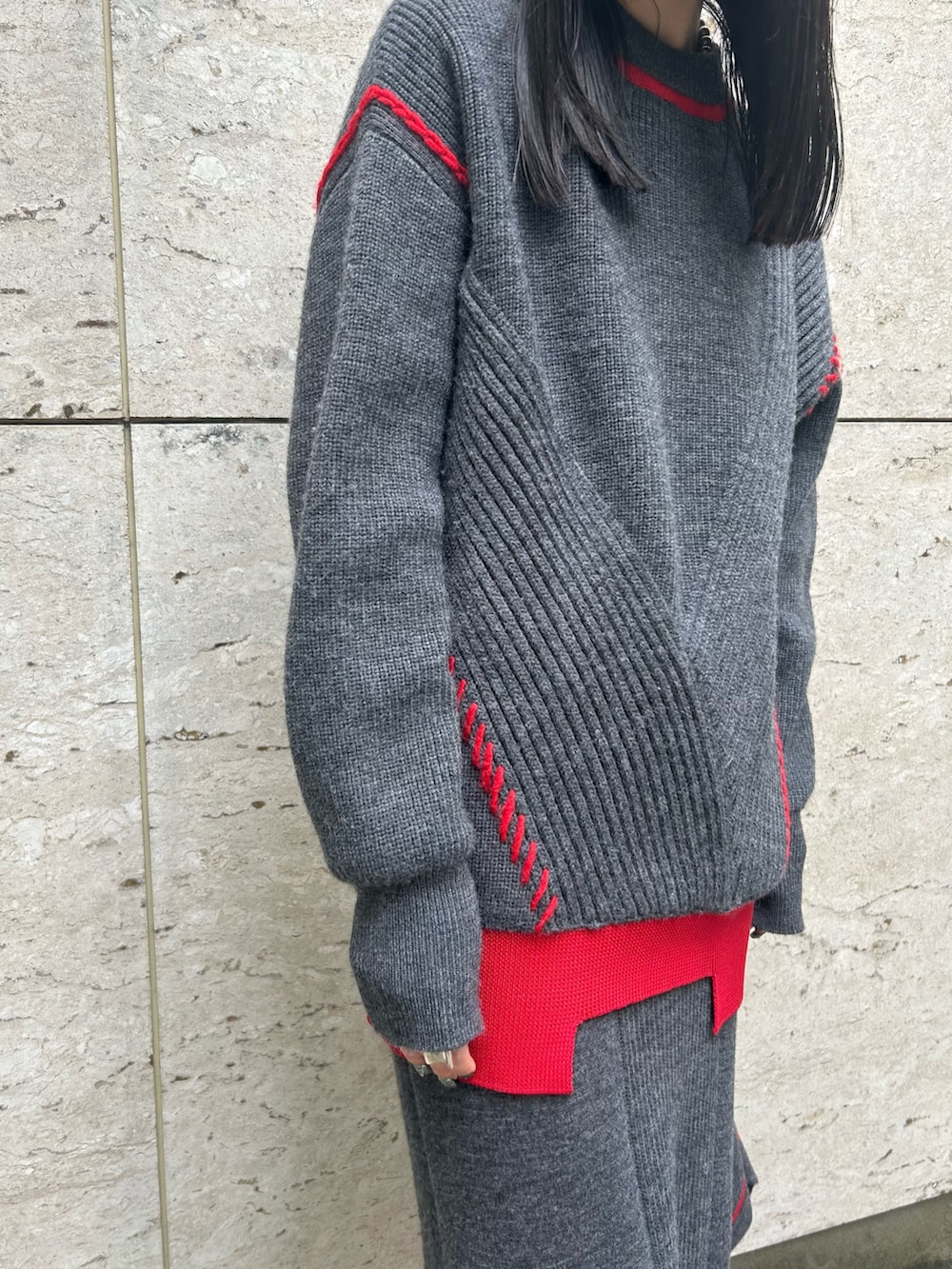 グレー系のスカート、グレー系のニット/セーター、シルバー系のブーツを着用したレディースの秋コーディネートの6枚目の写真