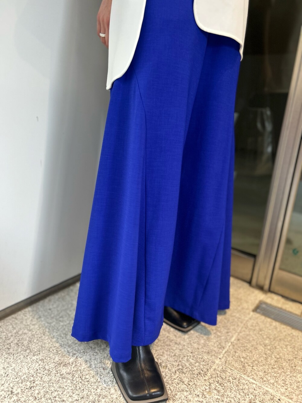 ホワイト系のTシャツ/カットソー、ブラック系のパンプス、ブルー系のその他パンツを着用したレディースの冬コーディネートの7枚目の写真