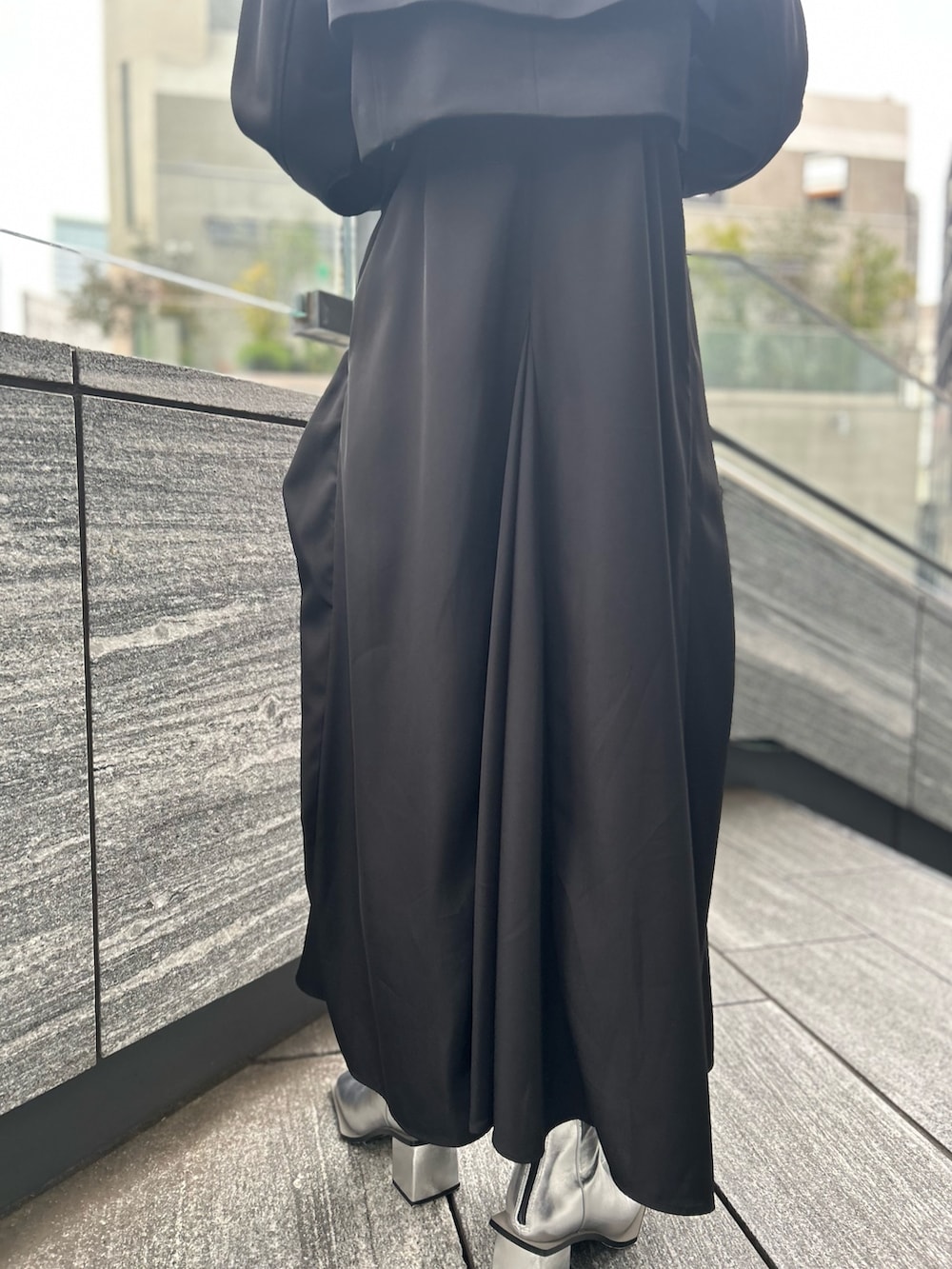 ブラック系のワンピース、ブラック系のテーラードジャケット、シルバー系のブーツを着用したレディースの春コーディネートの10枚目の写真