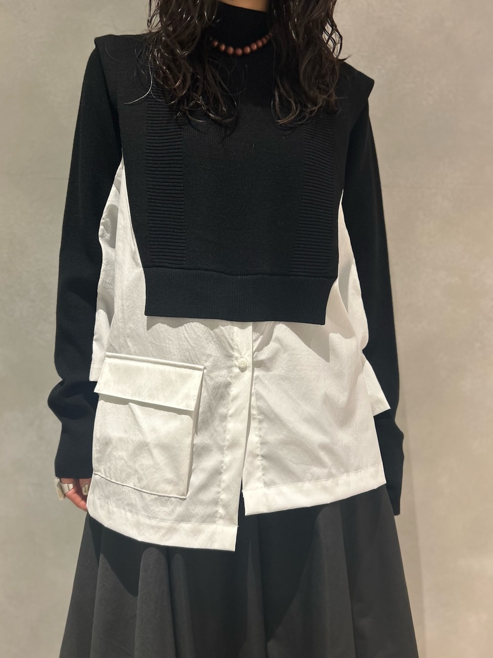 ブラック系のその他パンツ、ブラック系のニット/セーター、ブラウン系のネックレスを着用したレディースの冬コーディネートの2枚目の写真