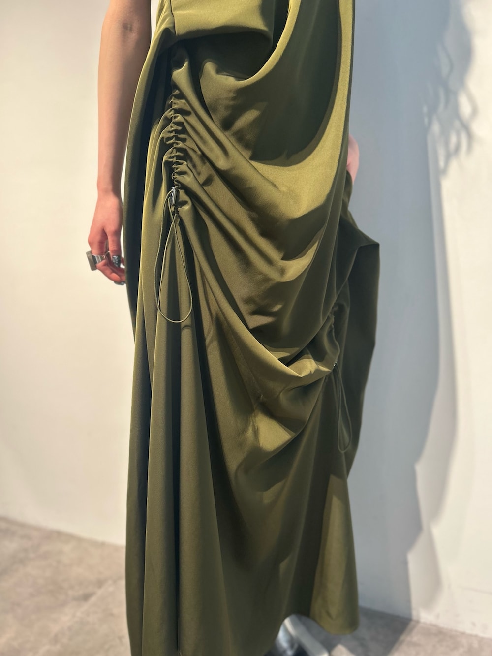 グリーン系のワンピース、ホワイト系のタンクトップ、シルバー系のパンプスを着用したレディースの春コーディネートの8枚目の写真