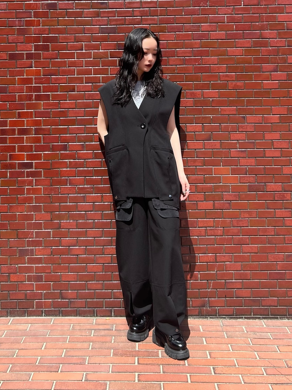 ブラック系のその他パンツ、シルバー系のタンクトップ、ブラック系のベストを着用したレディースの春コーディネートの2枚目の写真