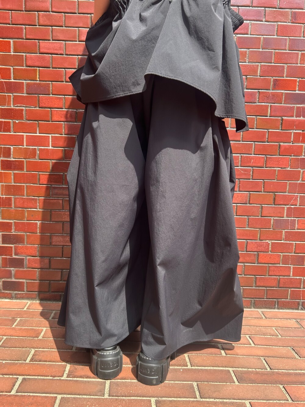 ブラック系のその他パンツ、ブラック系のタンクトップ、シルバー系のネックレスを着用したレディースの春コーディネートの6枚目の写真