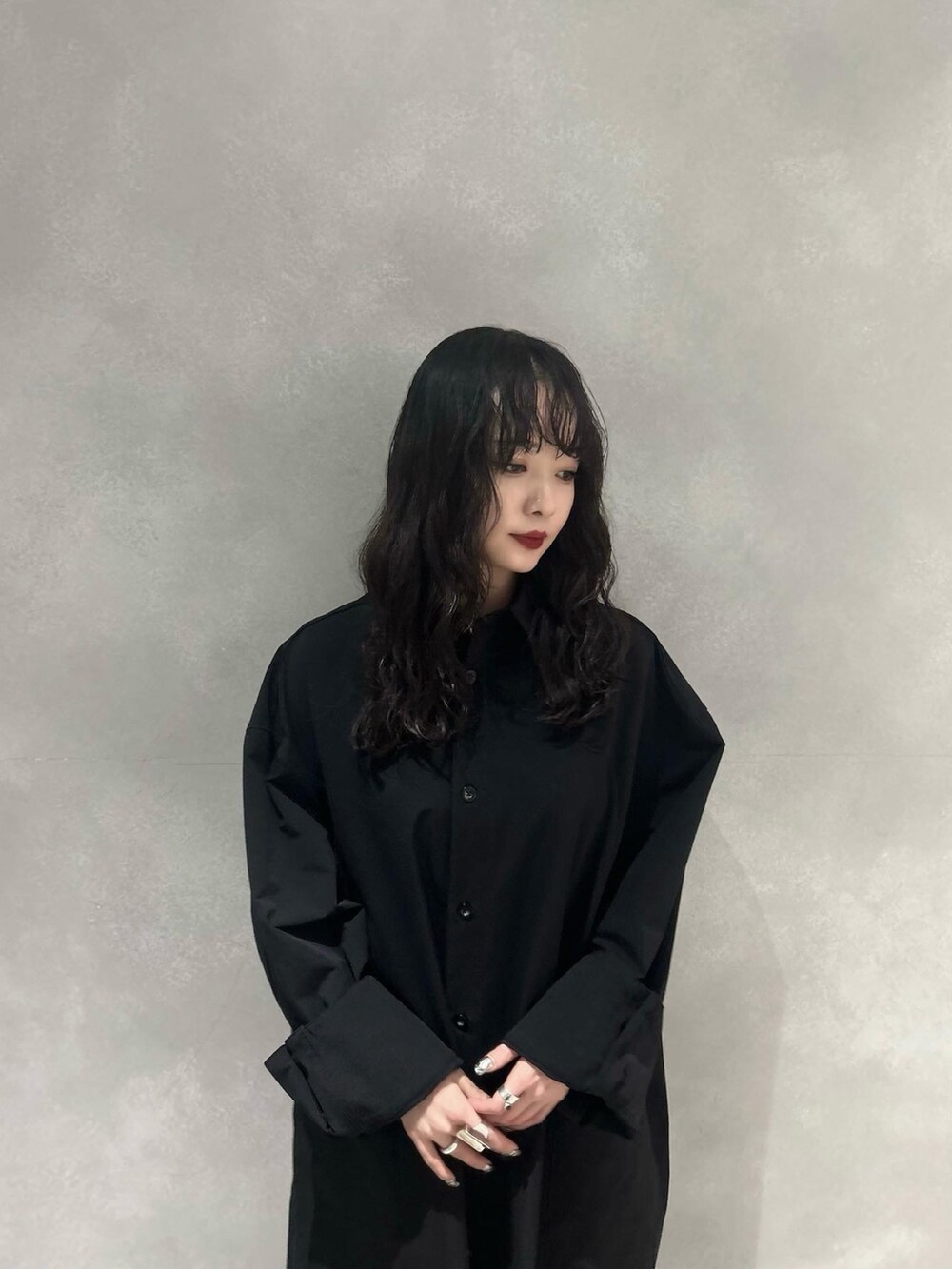 ブラック系のワンピース、レッド系のスカート、シルバー系のブーツを着用したレディースの冬コーディネートの5枚目の写真