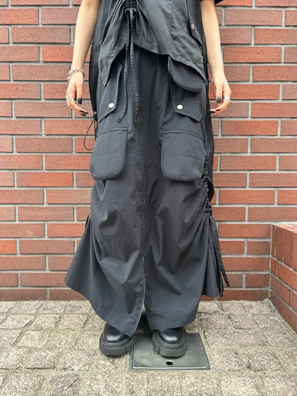 ブラック系のTシャツ/カットソー、ブラック系のスカート、ブラック系のローファーを着用したレディースの秋コーディネートの5枚目の写真