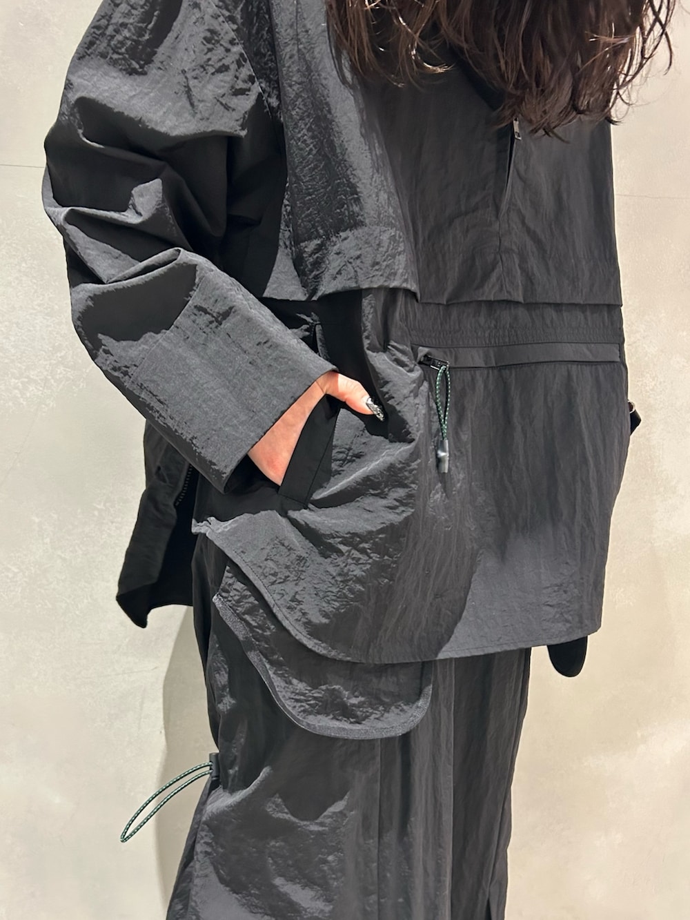 ブラック系のマウンテンパーカー、ブラック系のスカート、その他のサンダルを着用したレディースの春コーディネートの7枚目の写真