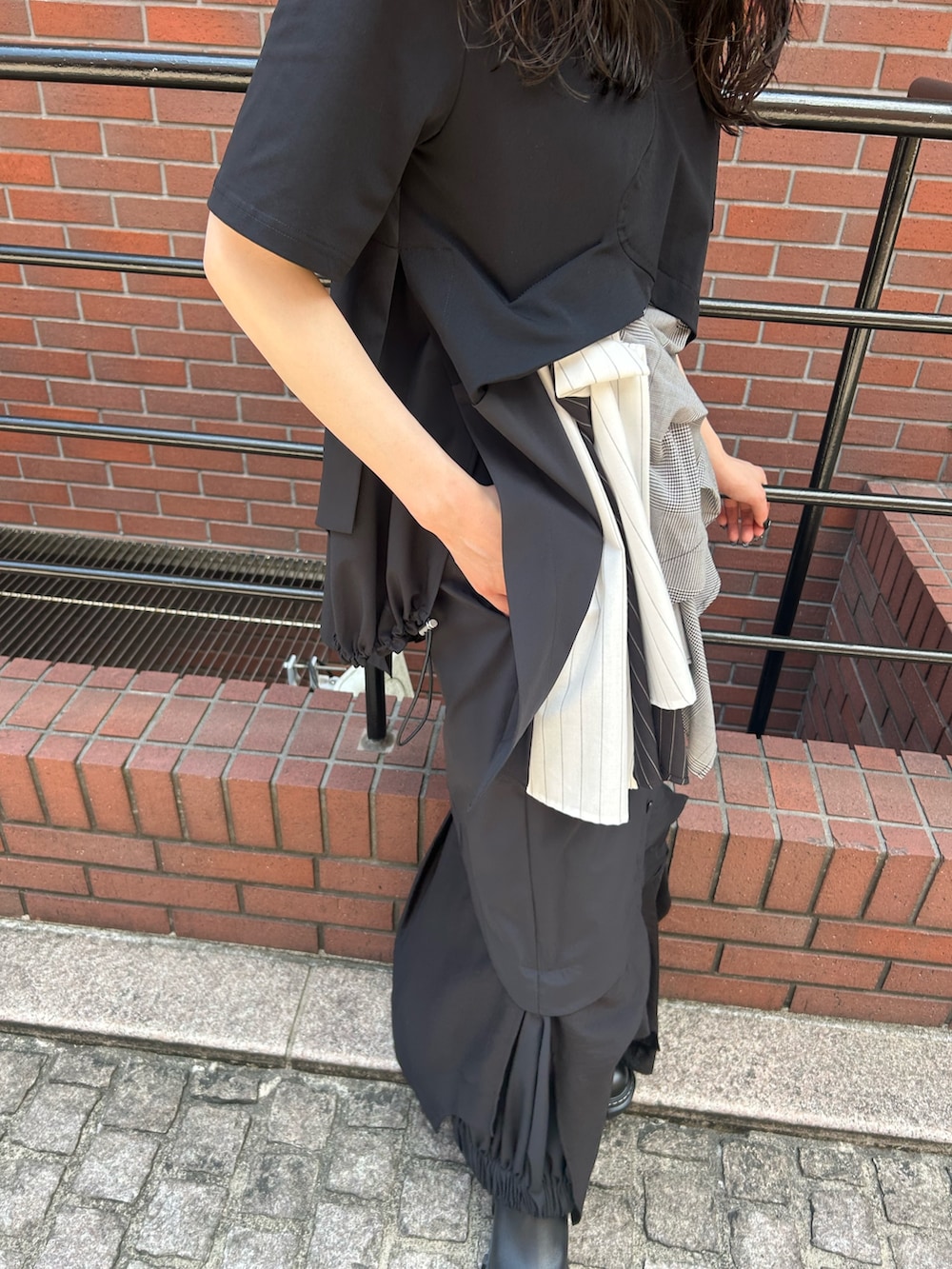 ブラック系のスカート、ブラック系のTシャツ/カットソー、ブラック系のブーツを着用したレディースの夏コーディネートの10枚目の写真