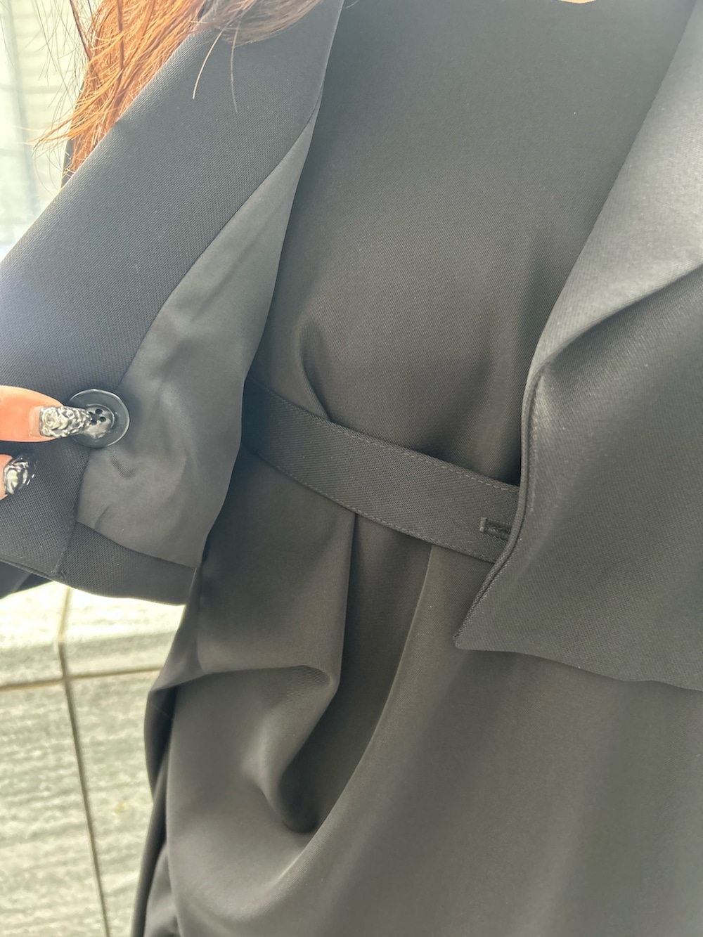 ブラック系のワンピース、ブラック系のテーラードジャケット、シルバー系のブーツを着用したレディースの春コーディネートの7枚目の写真