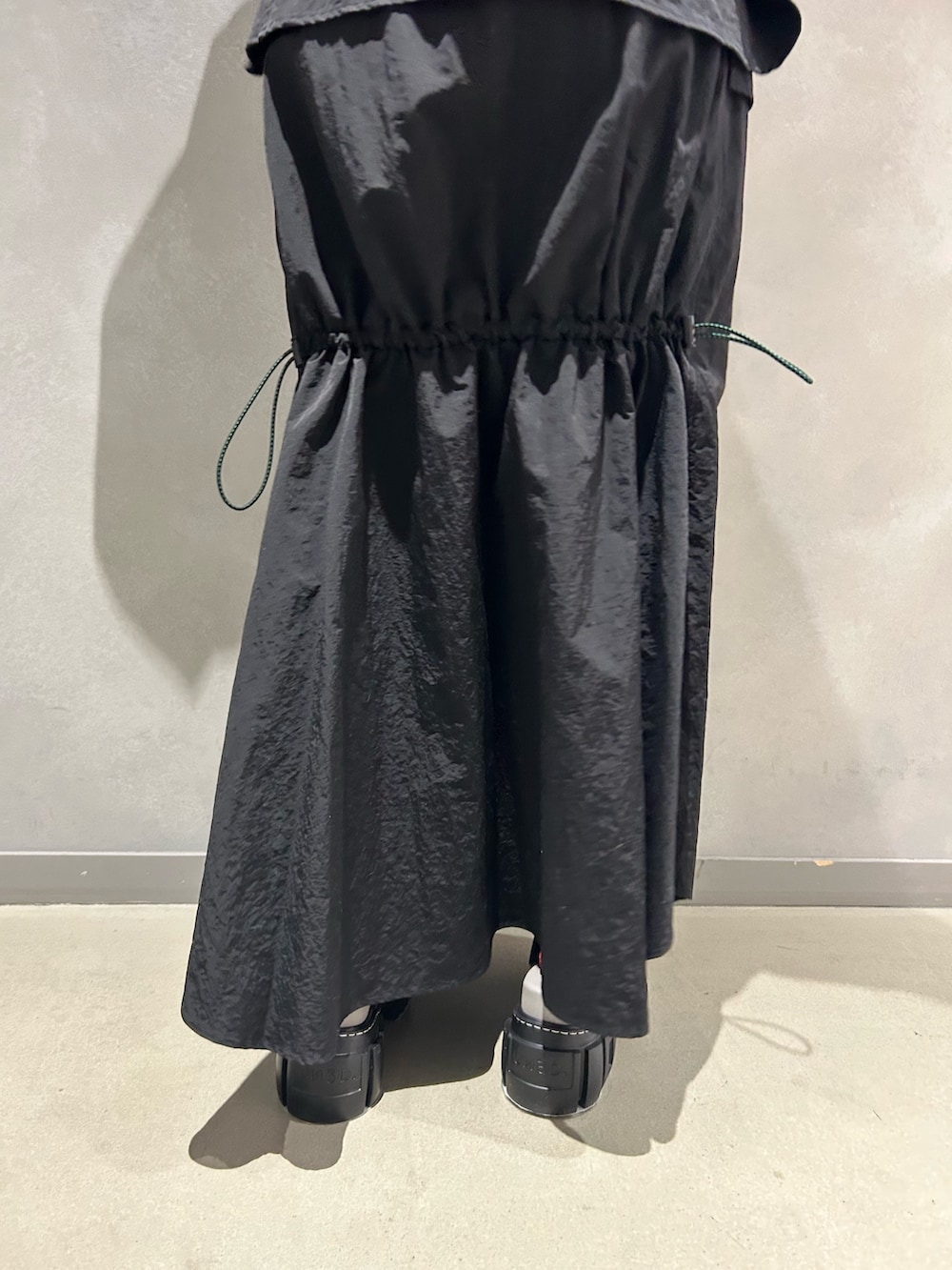 ブラック系のマウンテンパーカー、ブラック系のスカート、その他のサンダルを着用したレディースの春コーディネートの10枚目の写真