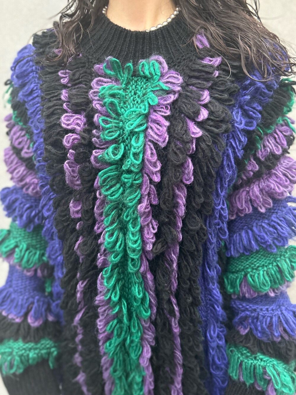 パープル系のニット/セーター、ブラック系のその他パンツ、ブラック系のブーツを着用したレディースの秋コーディネートの5枚目の写真