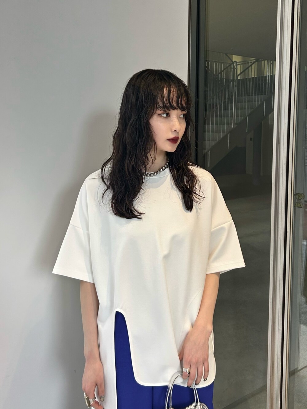 ホワイト系のTシャツ/カットソー、ブラック系のパンプス、ブルー系のその他パンツを着用したレディースの冬コーディネートの3枚目の写真