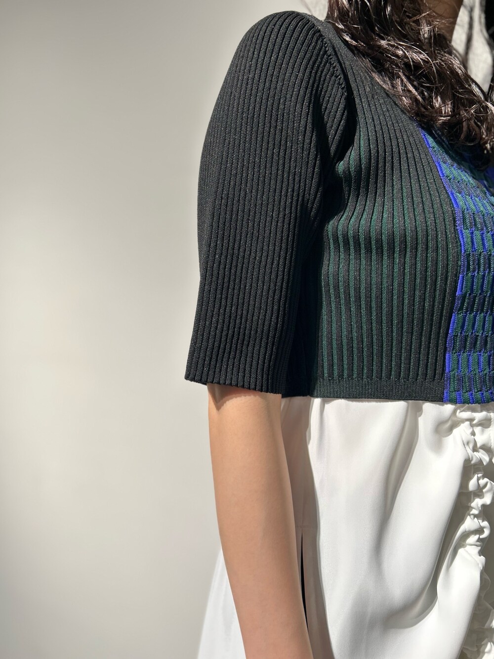 シルバー系のブーツ、ブラック系のスカート、ホワイト系のタンクトップを着用したレディースの冬コーディネートの5枚目の写真