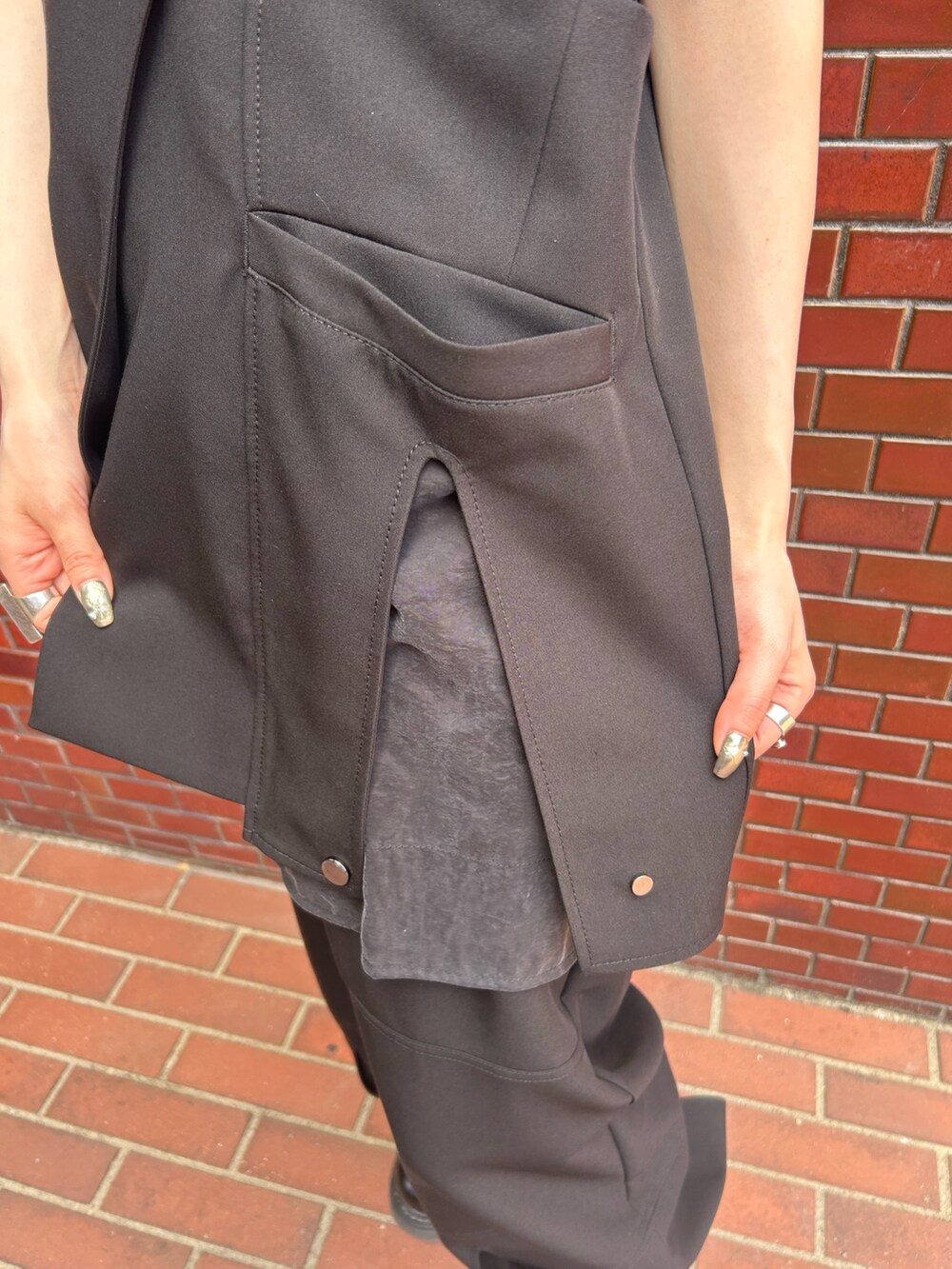 ブラック系のその他パンツ、シルバー系のタンクトップ、ブラック系のベストを着用したレディースの春コーディネートの8枚目の写真