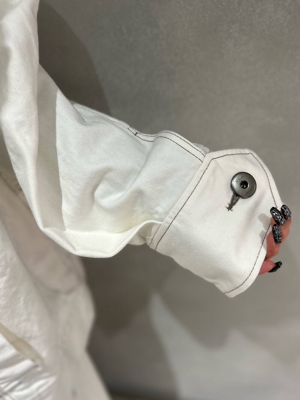 ホワイト系のデニムパンツ、ホワイト系のデニムジャケット、ブラック系のニット/セーターを着用したレディースの春コーディネートの10枚目の写真