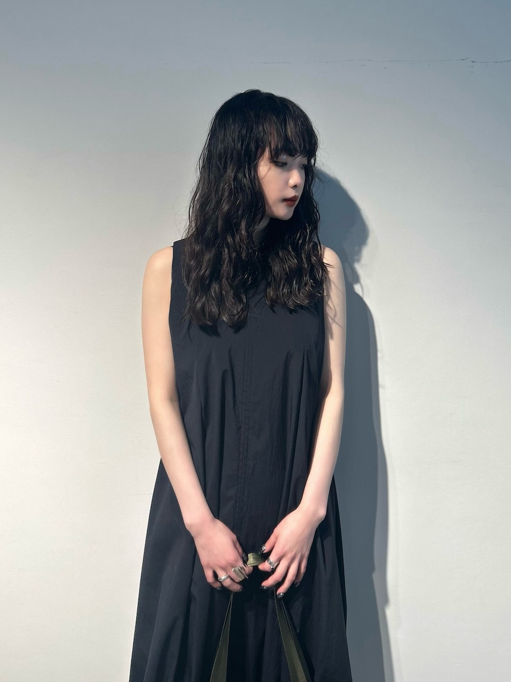 ブラック系のワンピース、グリーン系のトートバッグ、その他のサンダルを着用したレディースの夏コーディネートの3枚目の写真