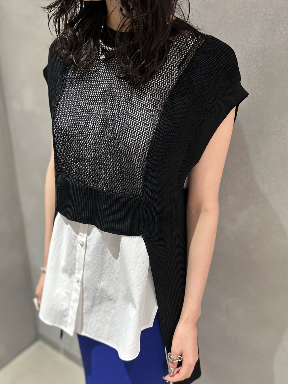 ブラック系のベスト、ホワイト系のシャツ/ブラウス、ブルー系のスカートを着用したレディースの夏コーディネートの4枚目の写真