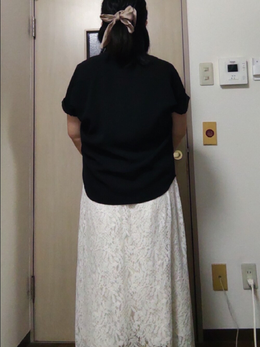 ブラック系のシャツ/ブラウス、ホワイト系のトートバッグ、ホワイト系のスカートを着用したレディースの夏コーディネートの2枚目の写真