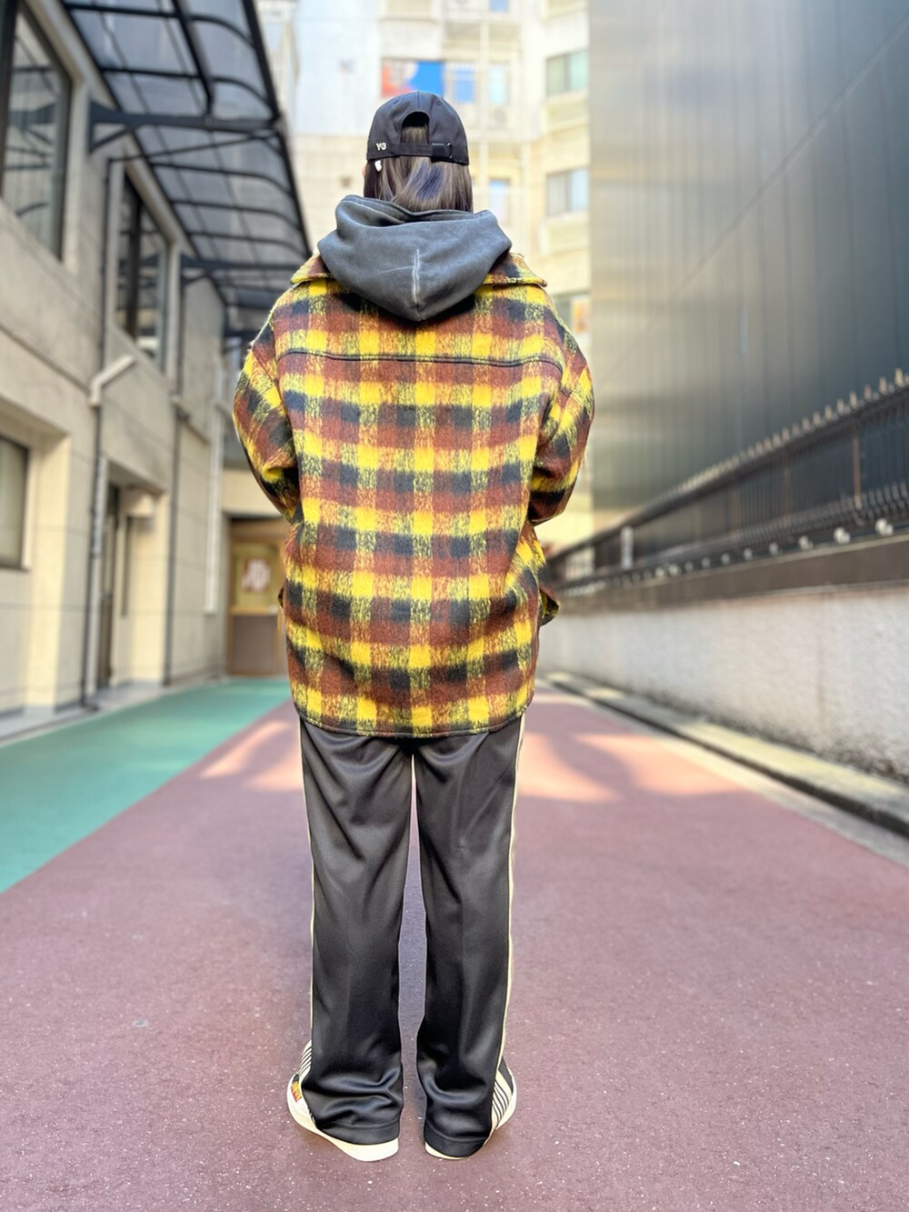 グレー系のパーカー、イエロー系のシャツ/ブラウス、パープル系のパンツを着用したレディースの冬コーディネートの2枚目の写真