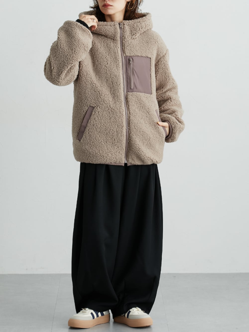 ブラック系のニット/セーター、ブラック系のその他パンツ、ブラウン系のカバーオールを着用したレディースの秋コーディネートの2枚目の写真