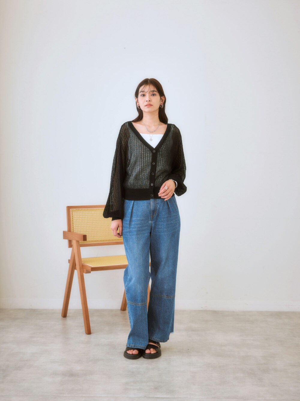 ブルー系のデニムパンツ、ブラック系のカーディガン/ボレロ、ホワイト系のTシャツ/カットソーを着用したレディースの春コーディネートの2枚目の写真