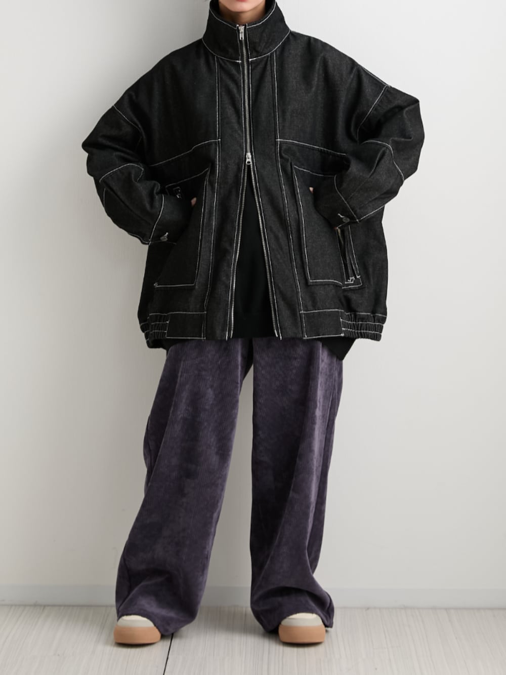 ブラック系のデニムジャケット、パープル系のその他パンツ、ブラック系のニット/セーターを着用したレディースの秋コーディネートの2枚目の写真