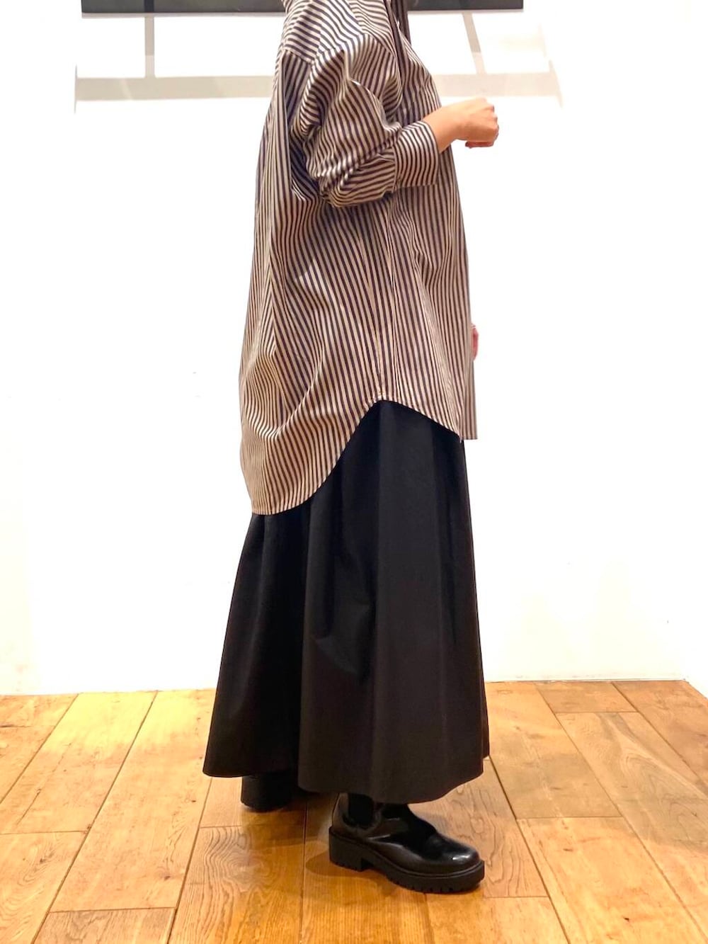 ブラック系のブーツ、グレー系のシャツ/ブラウス、ブラック系のスカートを着用したレディースの秋コーディネートの3枚目の写真