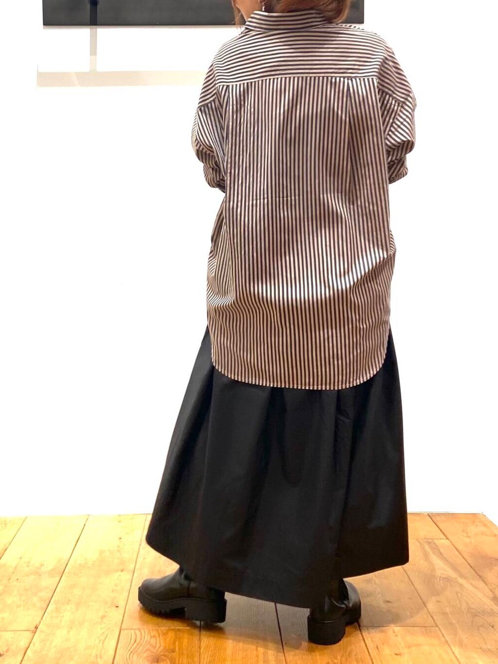 ブラック系のブーツ、グレー系のシャツ/ブラウス、ブラック系のスカートを着用したレディースの秋コーディネートの4枚目の写真