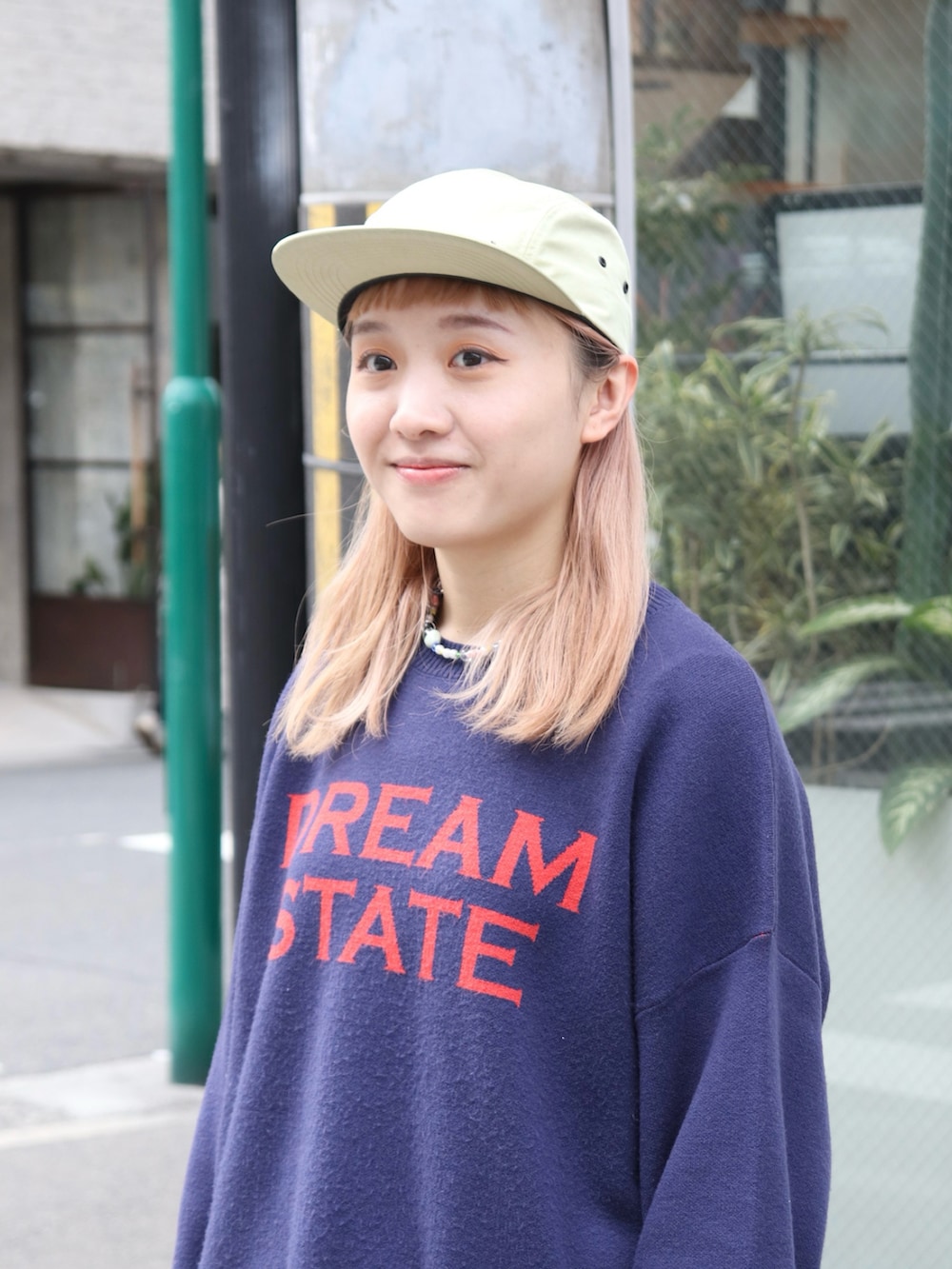 ブルー系のキャップを着用したレディースの春コーディネートの3枚目の写真