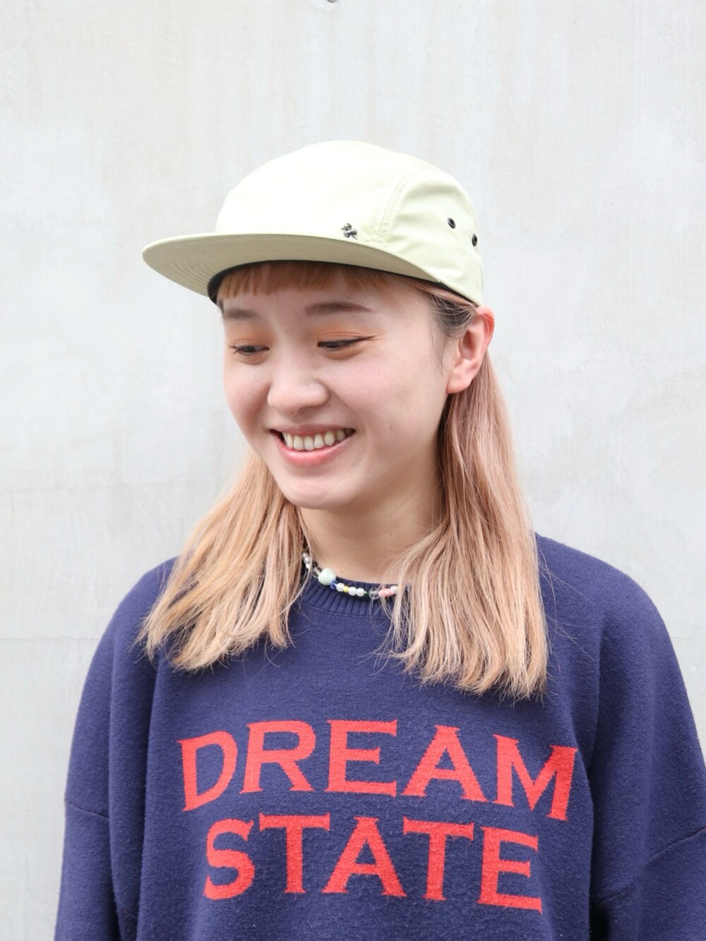 ブルー系のキャップを着用したレディースの春コーディネートの4枚目の写真