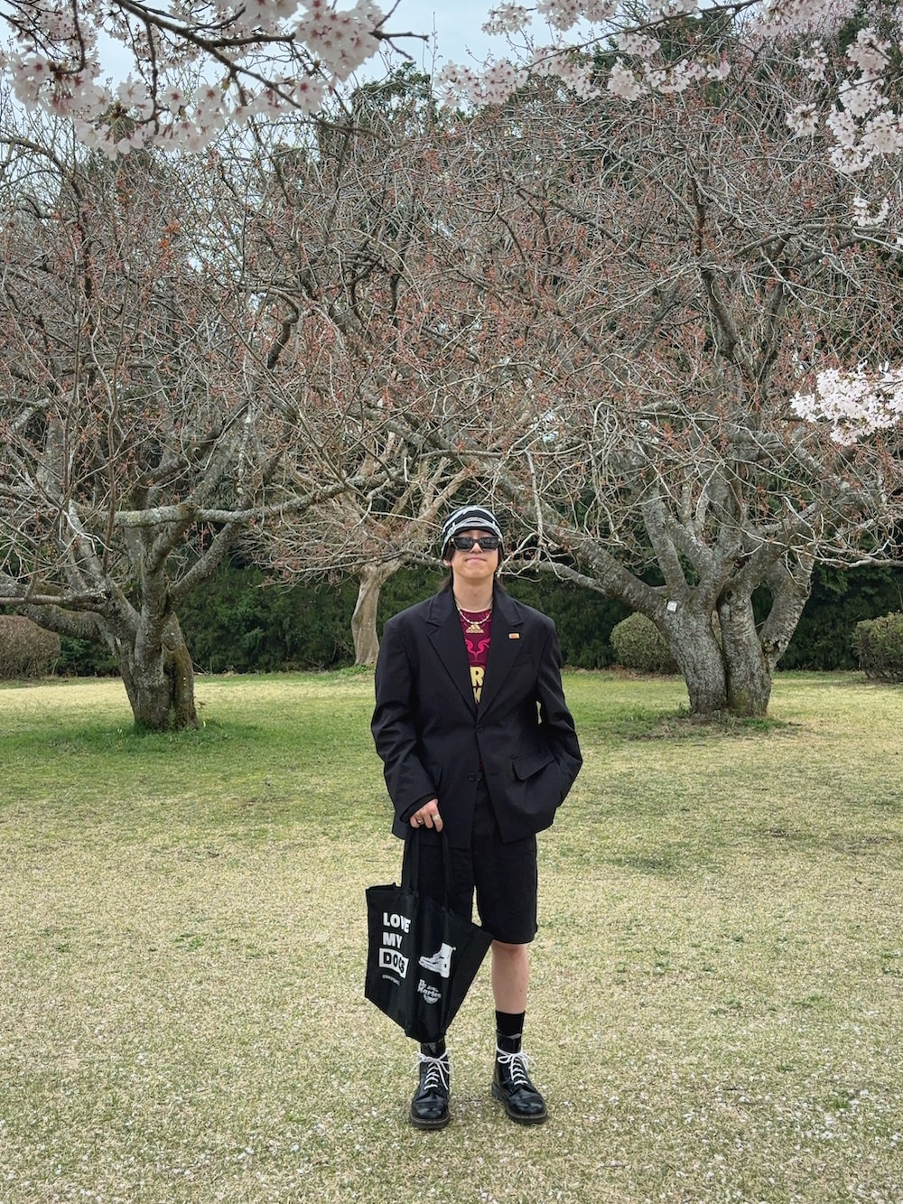 ブラック系のパンツ、ブラック系のジャケット/アウター、レッド系のトップスを着用したメンズの春コーディネートの2枚目の写真