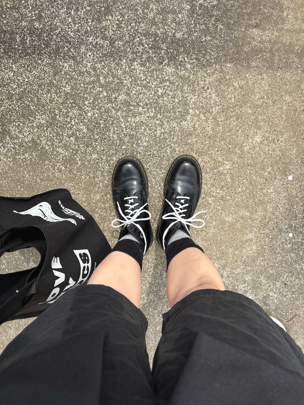 ブラック系のパンツ、ブラック系のジャケット/アウター、レッド系のトップスを着用したメンズの春コーディネートの3枚目の写真